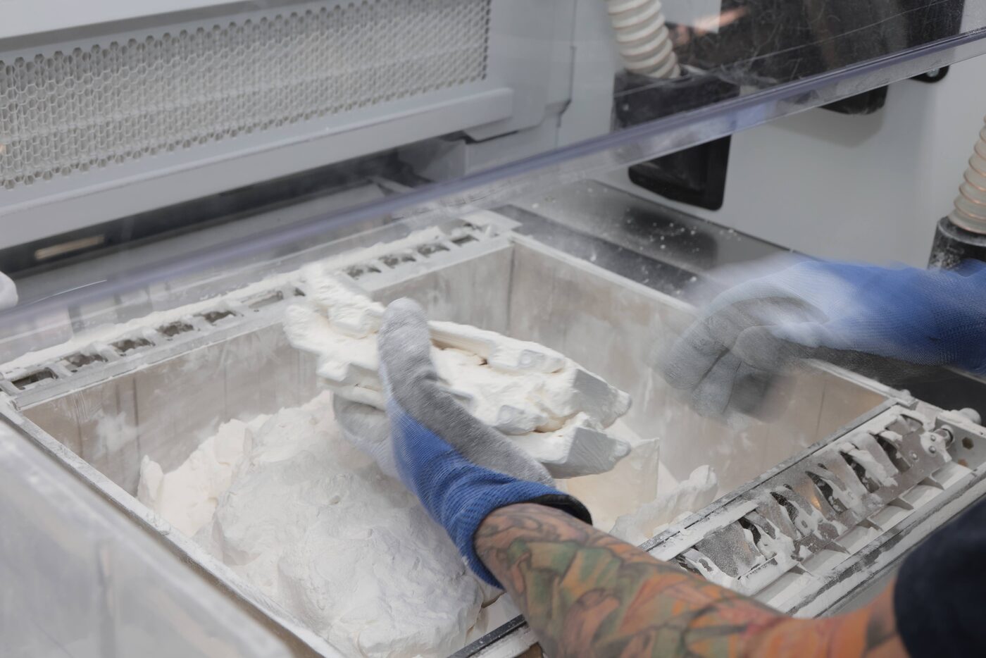 Engineer depowdering a freshly printed HP Multi Jet Fusion part